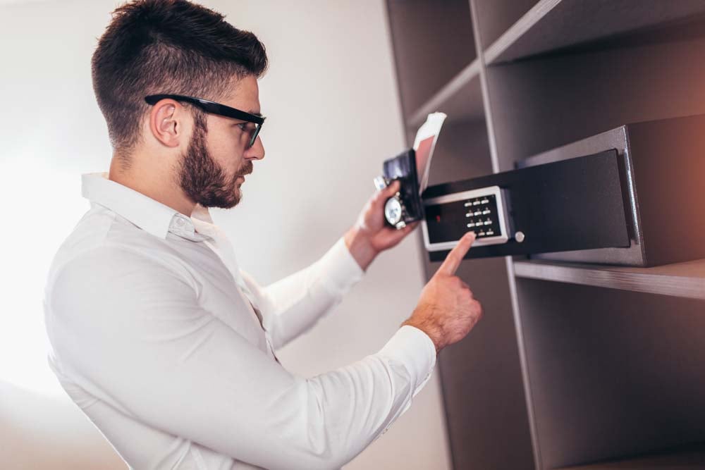 Person placing financial documents in home safe
