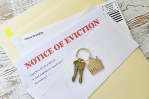 A photo of paperwork sitting on a wood table, one of which says Notice of Eviction in bright red letters.