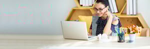 Woman enjoying her work on a laptop.
