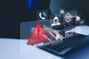 A blurry photo of a mysterious person typing on a laptop, superimposed with transparent icons of a hooded figure, an email, a credit card, a phone, and a big red triangle with an exclamation point and the word Scam beneath it.